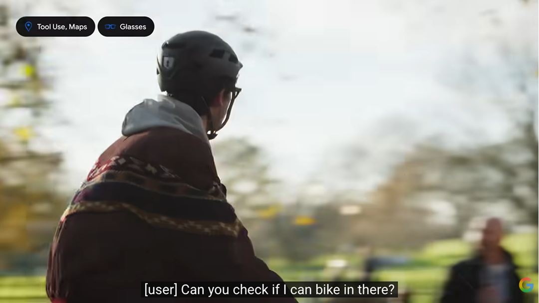 Rear view of a person wearing a bicycle helmet and a patterned poncho, pausing at a park entrance. A subtitle reads "Can you check if I can bike in there?" Labels indicate Tool Use, Maps and Glasses.